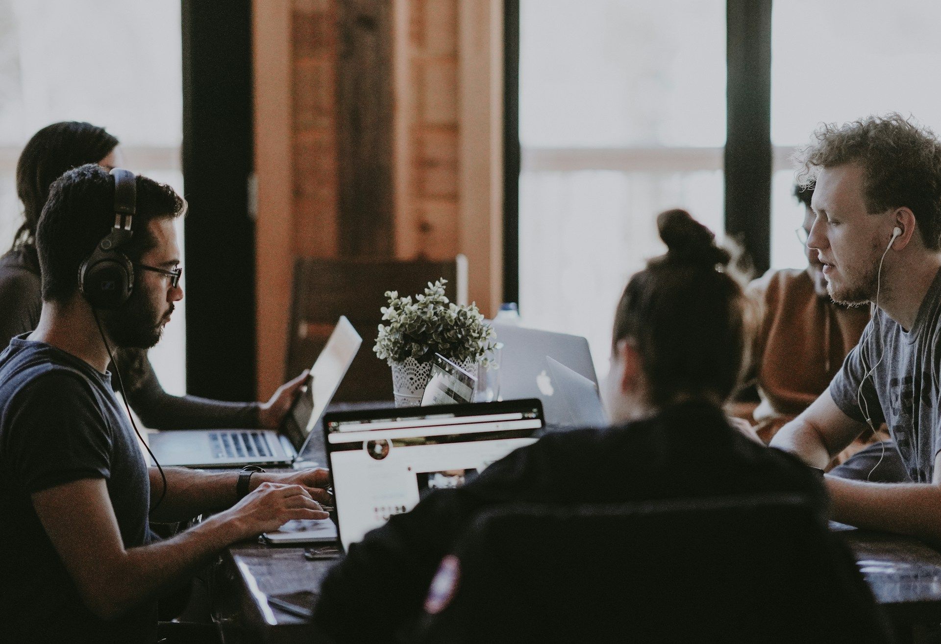 A group of marketing experts siting in a table working in their laptops