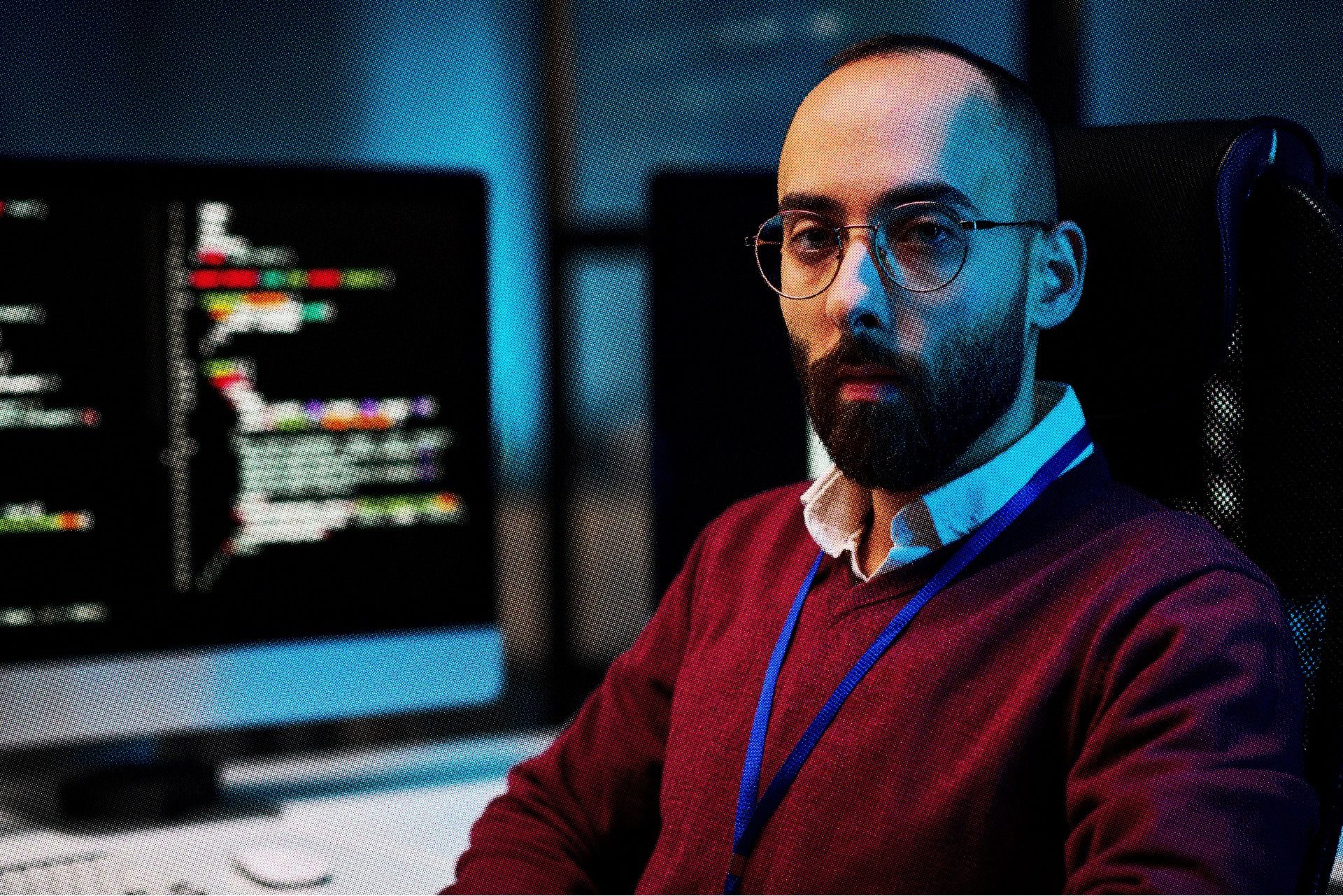 A developer looking at the camera with code behing him